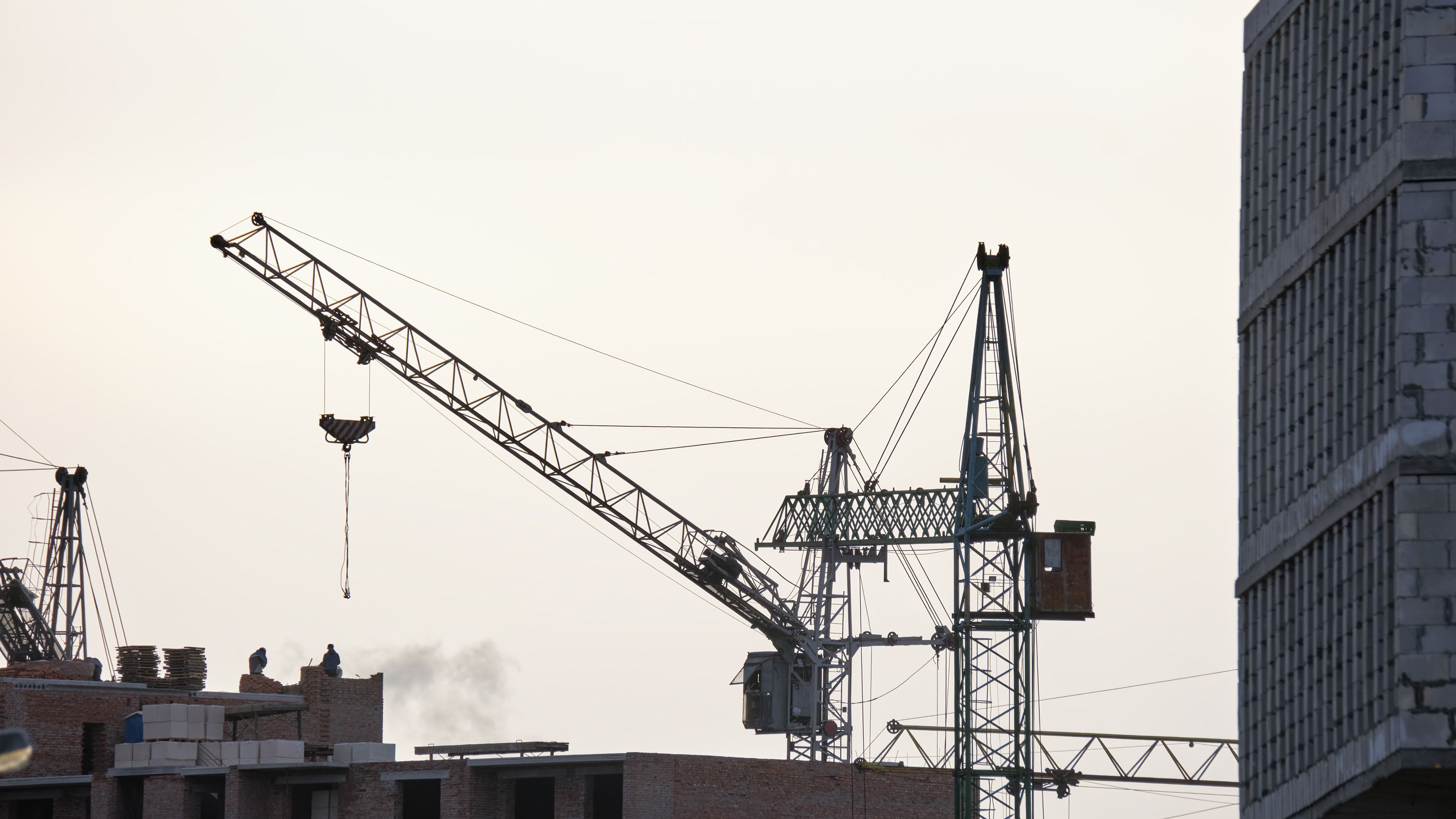 Edificio de hormigón en altura en construcción con grúa torre